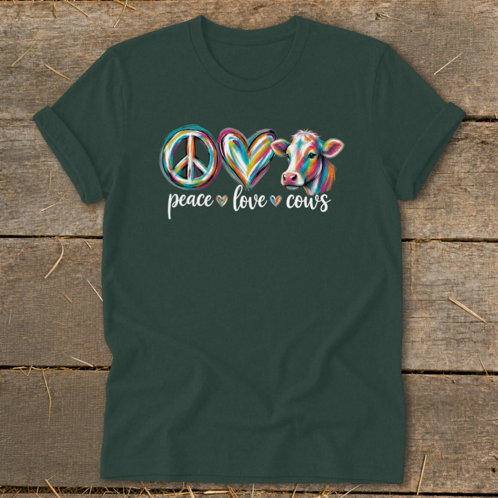 Green t-shirt with colorful peace sign, heart, and cow art with text "peace love cows".