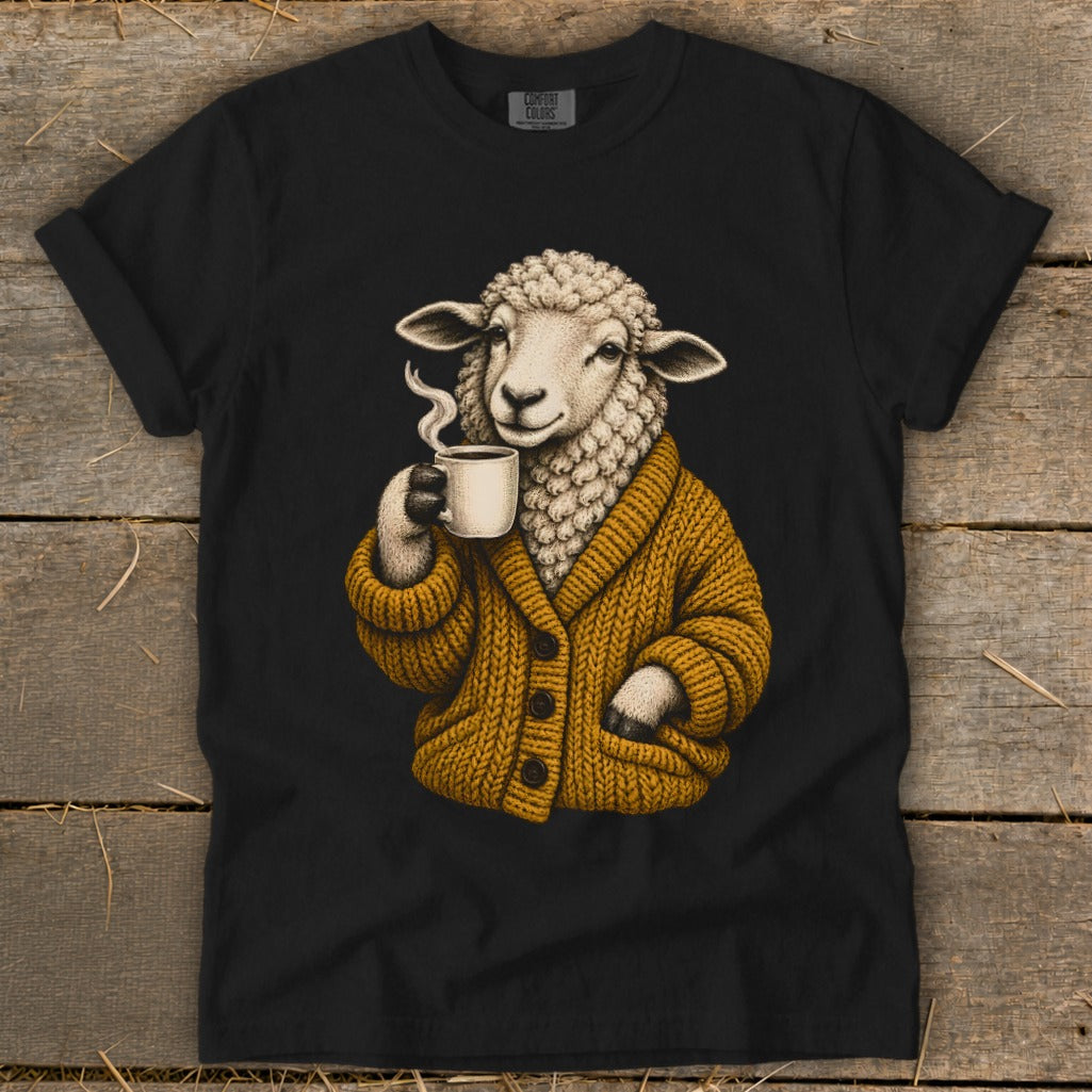 A black t-shirt features a graphic of a sheep wearing a mustard-yellow cardigan while holding a steaming mug.