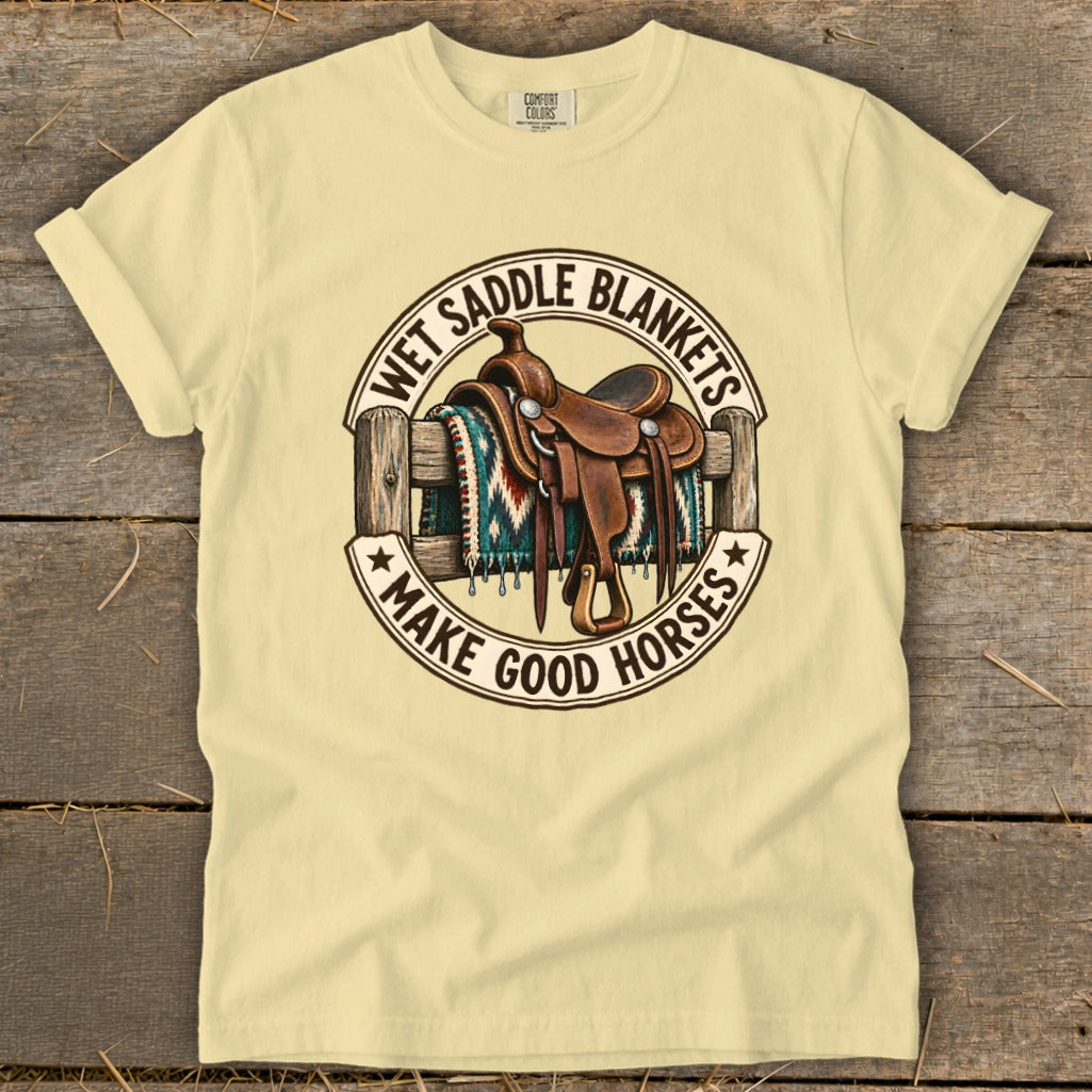 T-shirt with a western saddle on a fence, featuring text "Wet Saddle Blankets Make Good Horses".