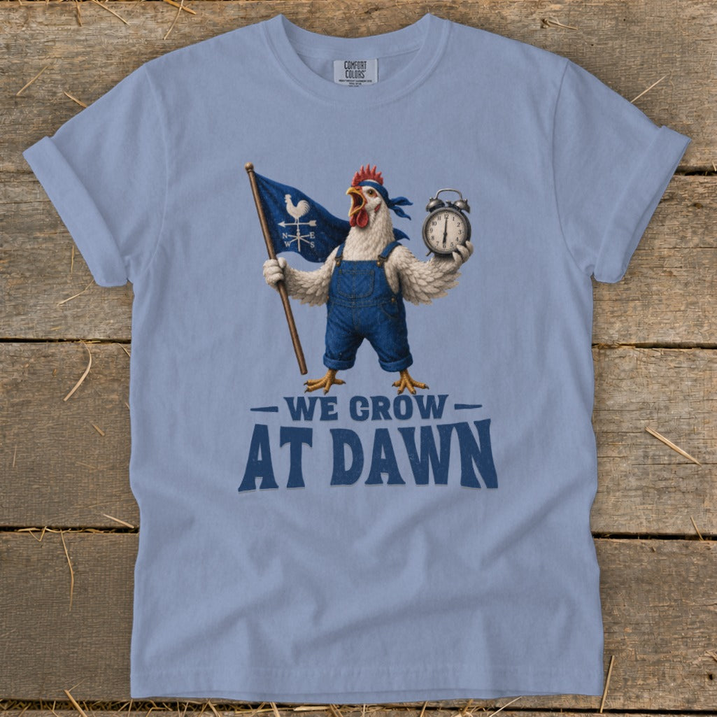 A chicken in overalls holds a flag and alarm clock, with text "We Grow At Dawn."
