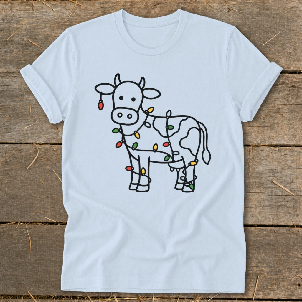 White t-shirt with a black outline of a cow wrapped in colorful Christmas lights.