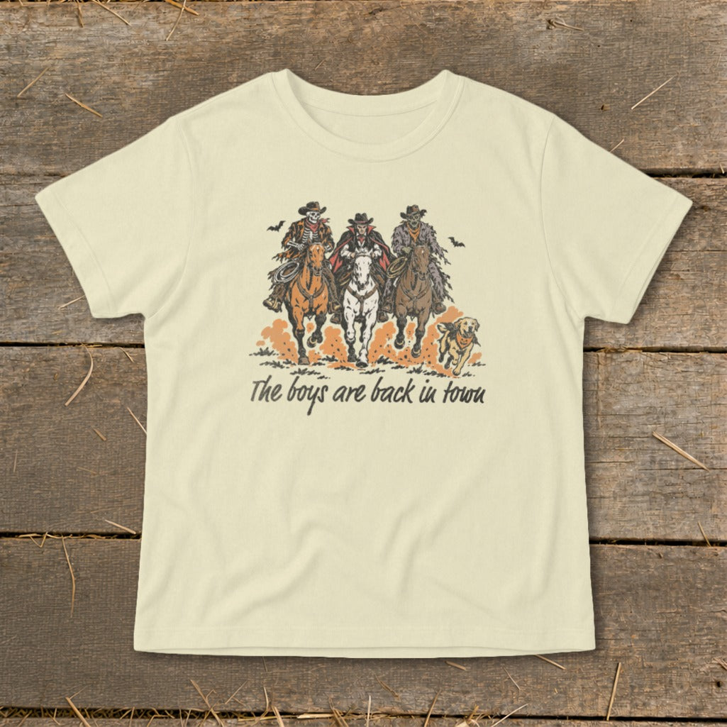 Skeleton, vampire, and zombie cowboys ride horses with text "The boys are back in town."