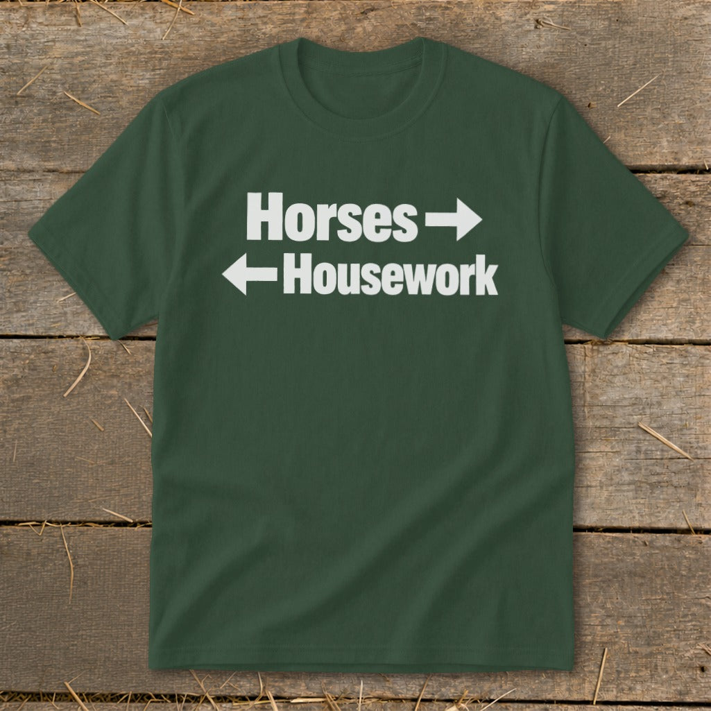 A dark green crewneck t-shirt with white text reading Horses with a right arrow and Housework with a left arrow.