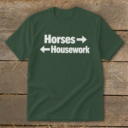 A dark green crewneck t-shirt with white text reading Horses with a right arrow and Housework with a left arrow.