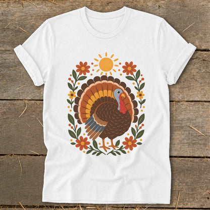 White t-shirt with colorful cartoon turkey and floral sun graphic.