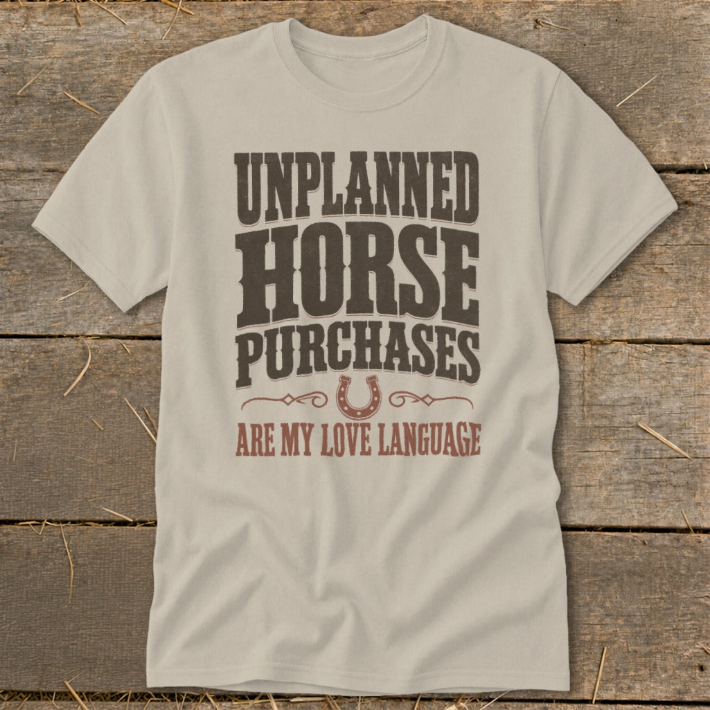 Light tan t-shirt with "Unplanned Horse Purchases Are My Love Language" text and horseshoe graphic.