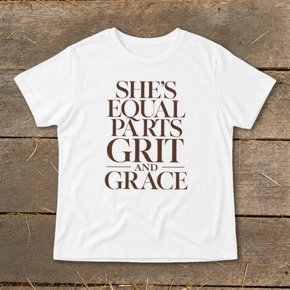 White t-shirt with brown text reading "She's Equal Parts Grit And Grace."