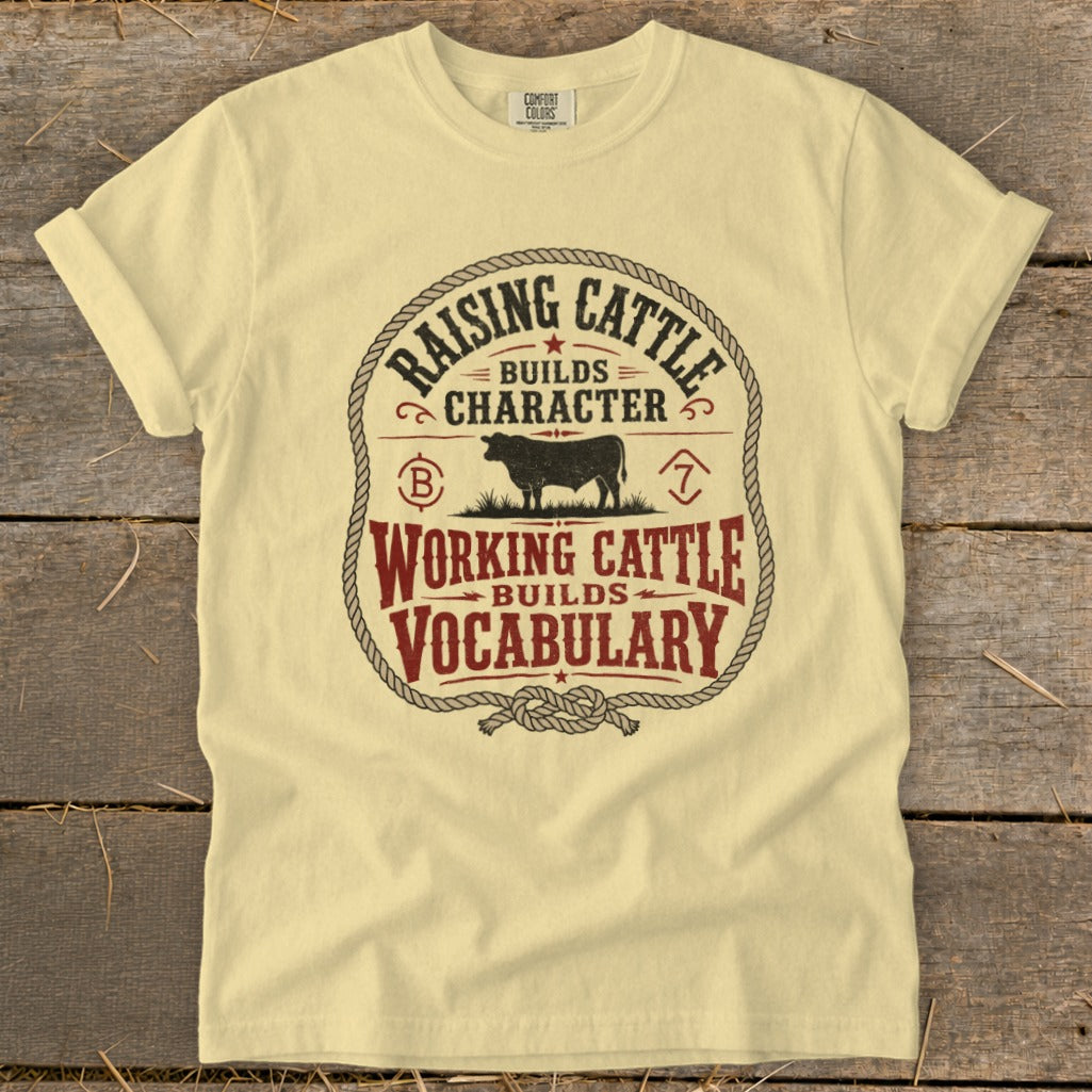 Light yellow t-shirt with "Raising Cattle Builds Character, Working Cattle Builds Vocabulary" graphic.