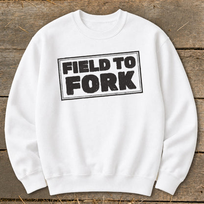 A white crewneck sweatshirt featuring a black boxed graphic with the text "FIELD TO FORK" centered on the chest.