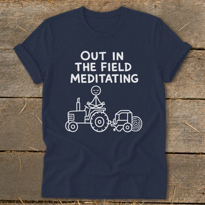 Navy t-shirt with "Out in the Field Meditating" and stick figure on tractor.