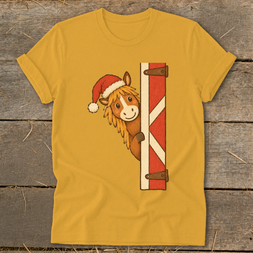 Horse wearing Santa hat peeks around barn door on yellow t-shirt.