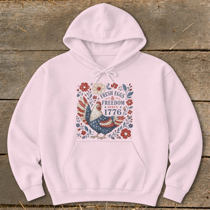 Pink hoodie with patriotic chicken design and "Fresh Eggs & Freedom Since 1776" text.