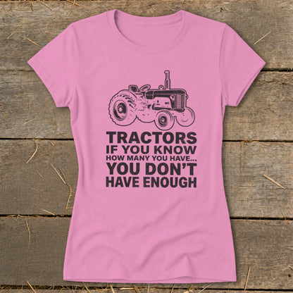 Pink t-shirt with a tractor graphic and text that reads "Tractors if you know how many you have... You don't have enough".