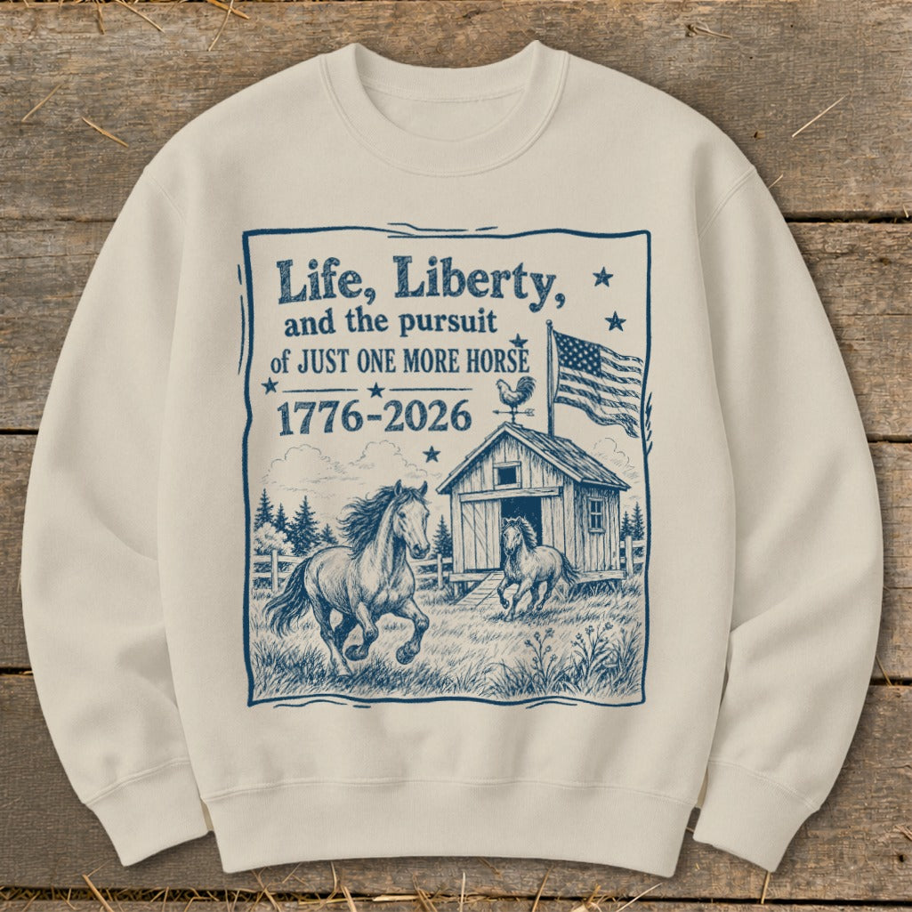 Cream sweatshirt with "Life, Liberty, and the pursuit of JUST ONE MORE HORSE 1776-2026" text and horses.