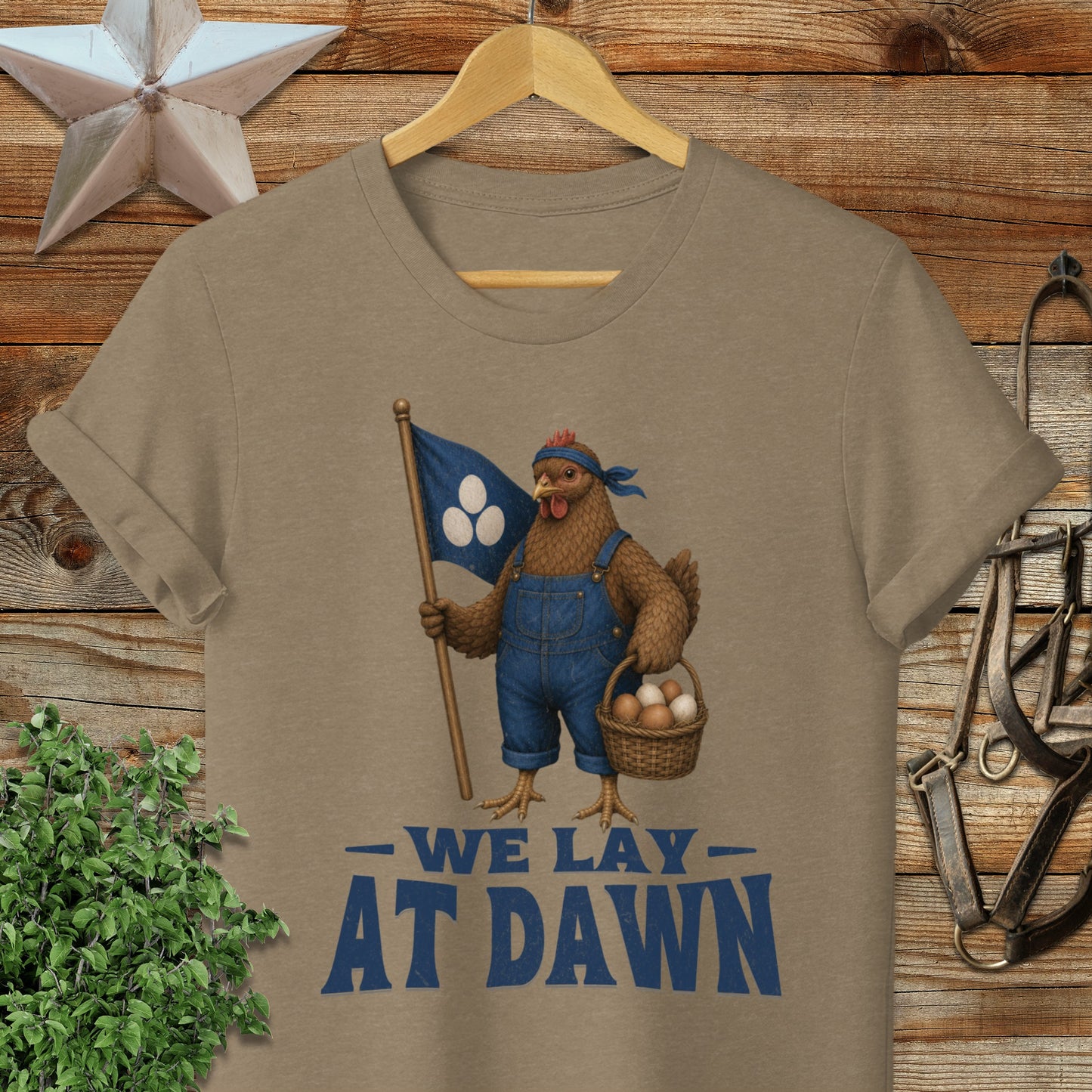T-shirt with a chicken holding a flag and basket, text "WE LAY AT DAWN".