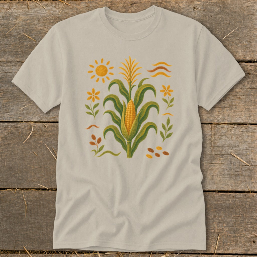 T-shirt with a stylized corn stalk, sun, flowers, and seeds graphic.