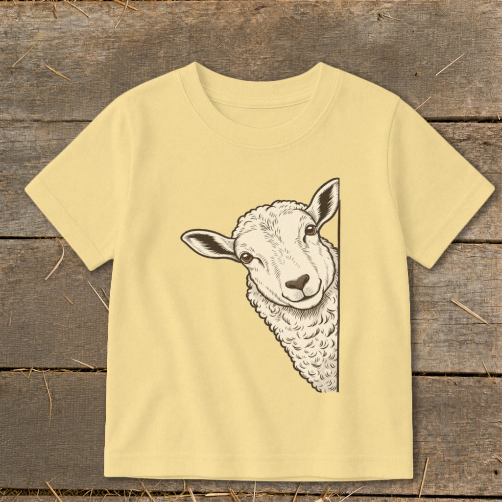 Cream t-shirt with a sheep peeking from the side of the graphic.