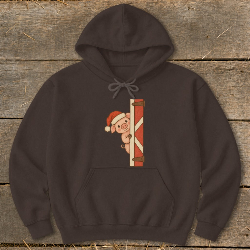 Brown hoodie with a cartoon pig wearing a Santa hat peeking from behind a red barn door.