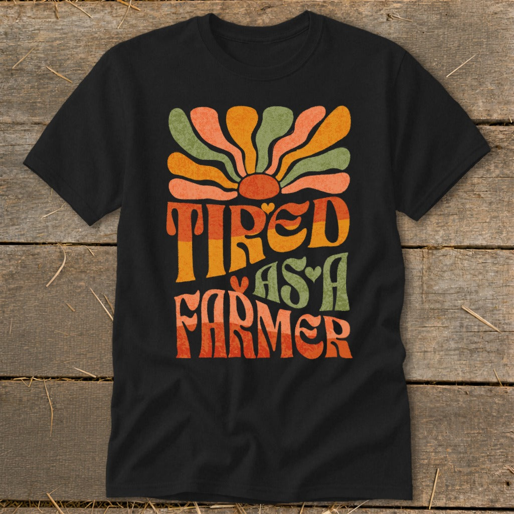 Black t-shirt with "Tired as a Farmer" text and retro sun graphic.