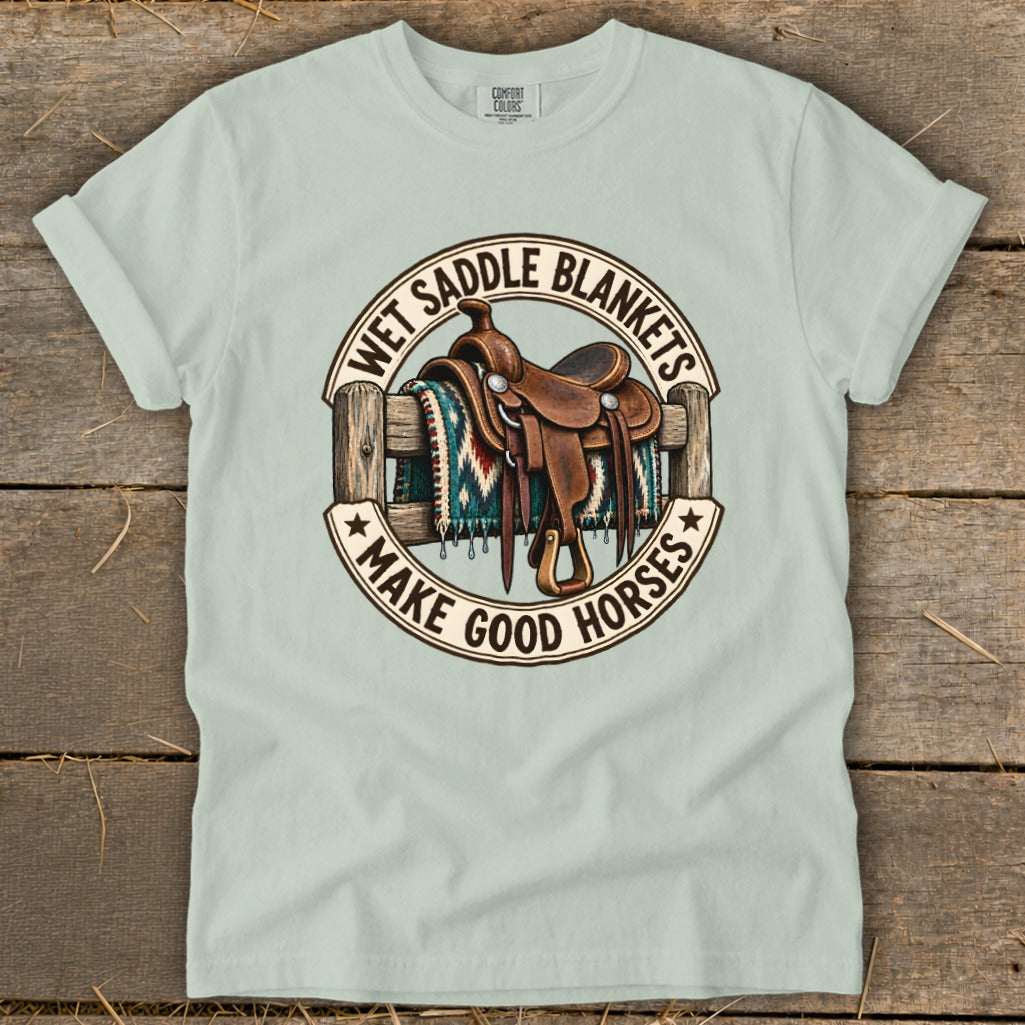 Light green t-shirt featuring a circular graphic with a western saddle and text that reads Wet Saddle Blankets Make Good Horses.