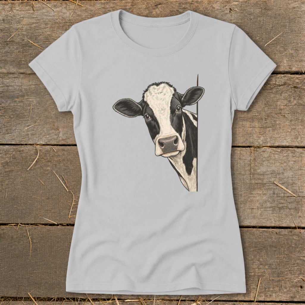 Black and white cow peeking from behind a corner on a light grey t-shirt.