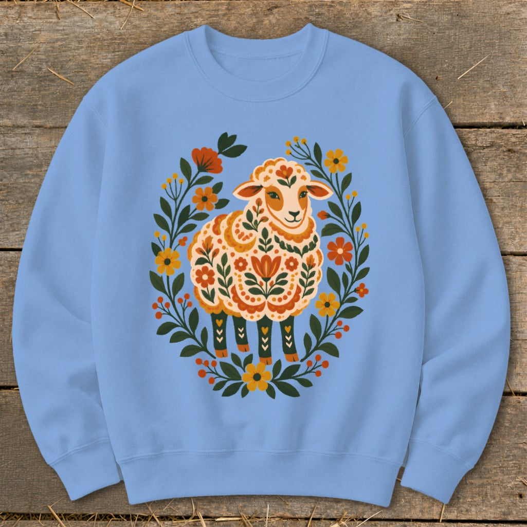 Light blue sweatshirt with a folk art sheep illustration surrounded by flowers.