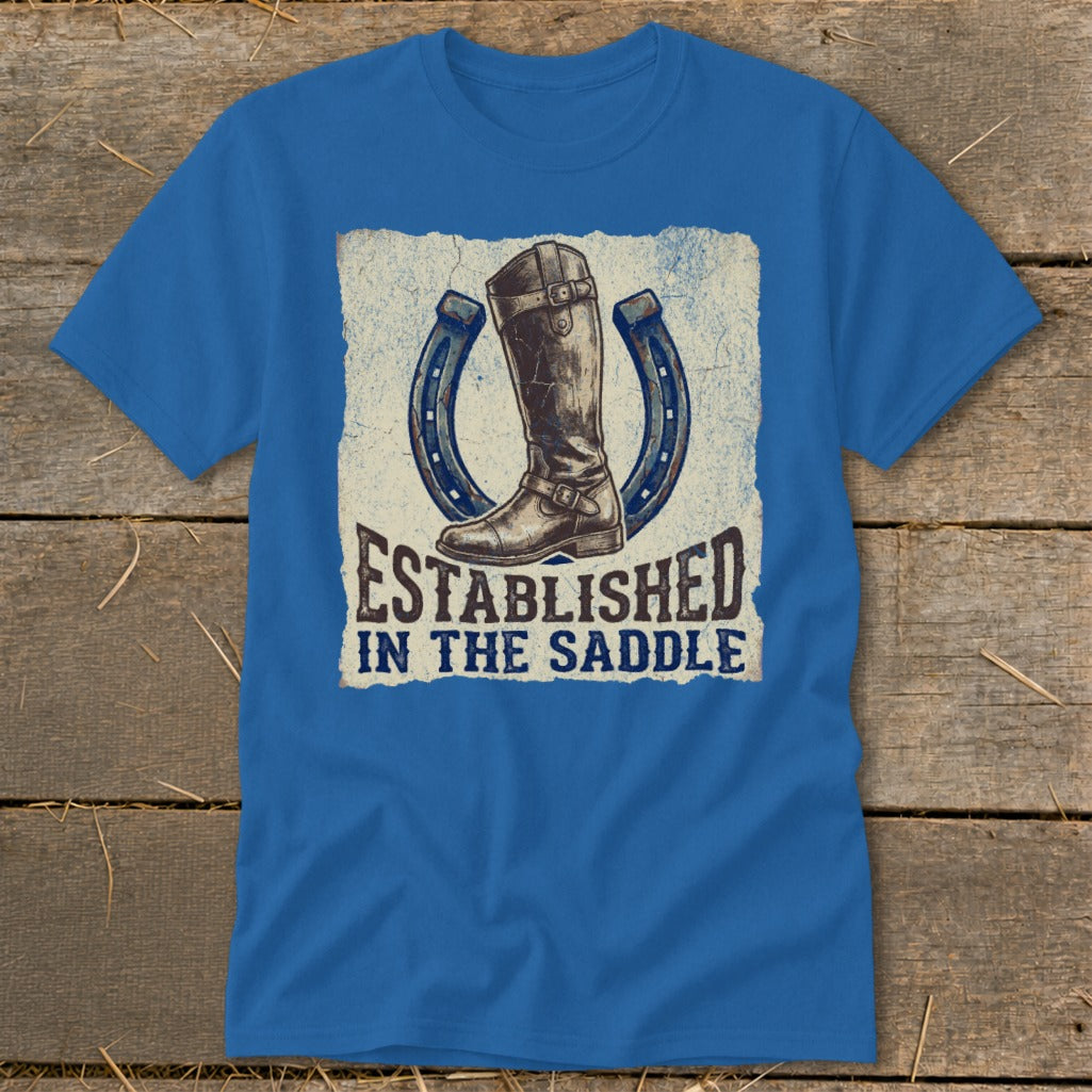 Blue t-shirt with a riding boot and two horseshoes, reading "Established in the Saddle."