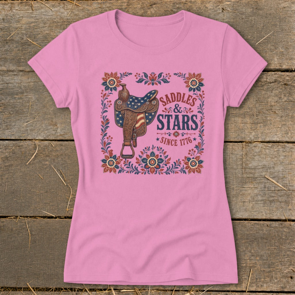 Pink t-shirt with western saddle and "Saddles & Stars Since 1776" graphic.