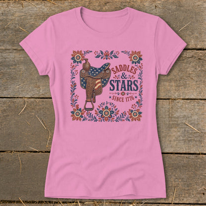 Pink t-shirt with western saddle and "Saddles & Stars Since 1776" graphic.