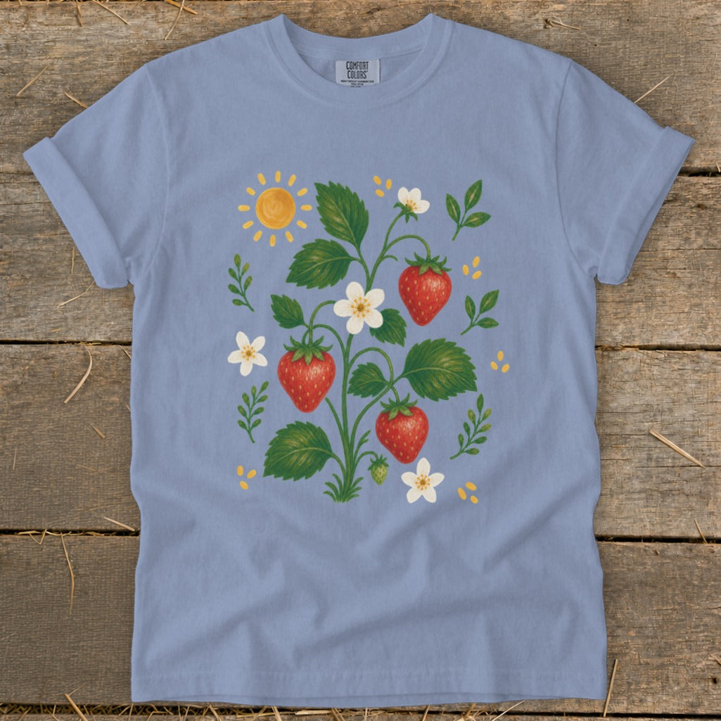 Light blue t-shirt with a whimsical strawberry plant, sun, and flower graphic.