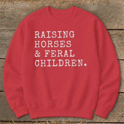 Red sweatshirt with white text: "RAISING HORSES & FERAL CHILDREN."