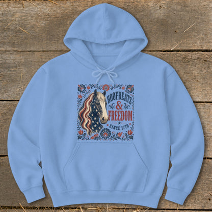 Light blue hoodie with horse and American flag design reading "Hoofbeats & Freedom Since 1776".