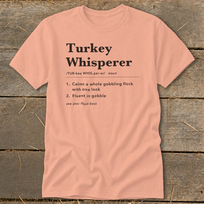 Peach t-shirt with "Turkey Whisperer" definition and humorous text.