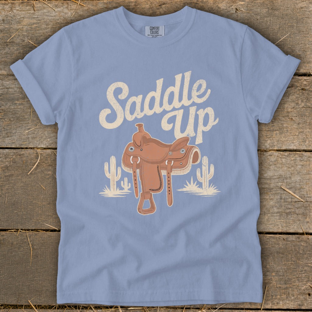Light blue t-shirt with "Saddle Up" text and a western saddle illustration.
