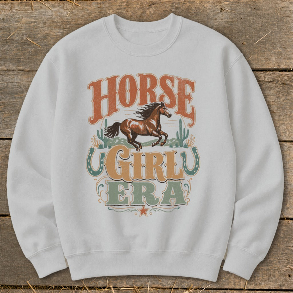 White sweatshirt with "Horse Girl Era" graphic featuring a running horse and desert cacti.