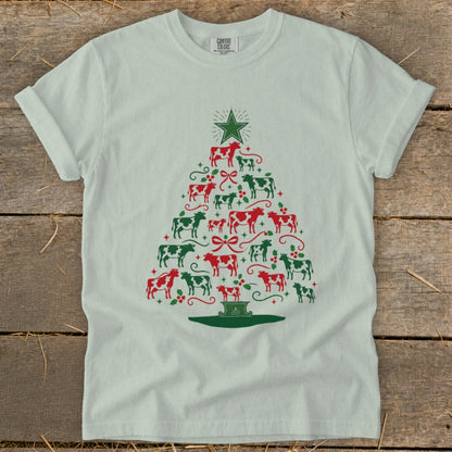 White t-shirt with a Christmas tree made of red and green cows and holly.