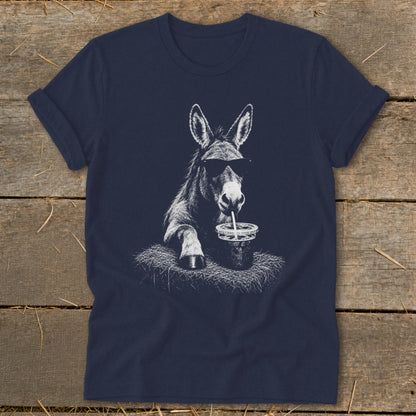 Donkey wearing sunglasses, drinking from a cup with a straw, on hay.