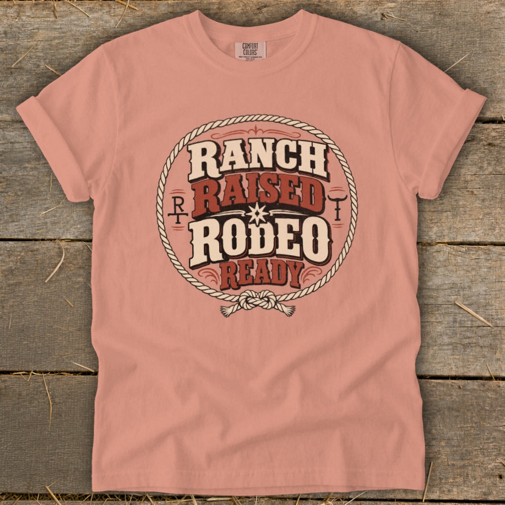 Coral pink t-shirt with a vintage western circular graphic featuring Ranch Raised Rodeo Ready text.