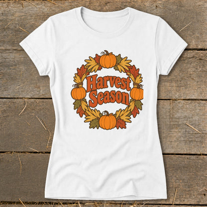 White t-shirt with "Harvest Season" text in a wreath of pumpkins and autumn leaves.