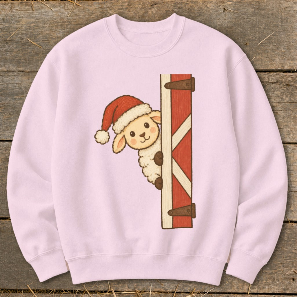 Pink crewneck sweatshirt with a Christmas sheep peeking from behind a red barn door.