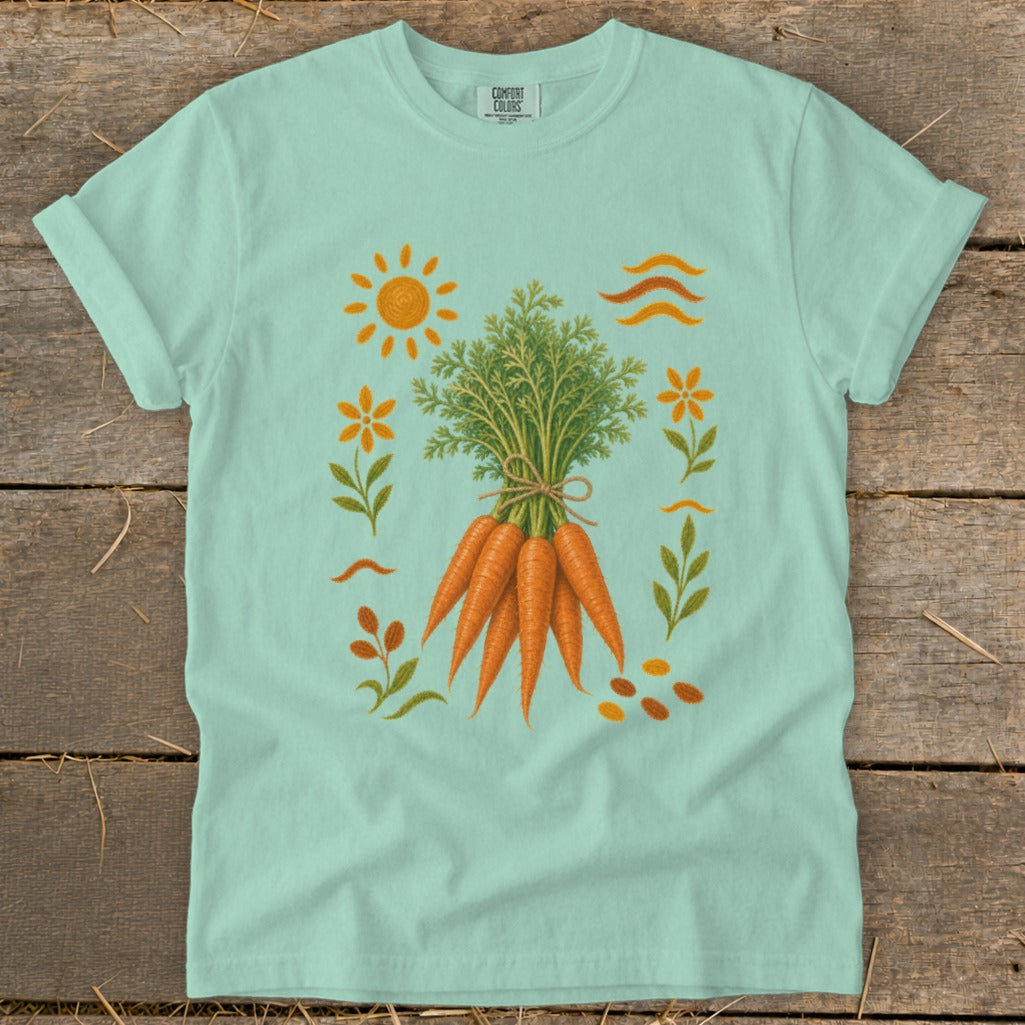 Mint green t-shirt with a graphic of a bunch of carrots surrounded by flowers and sun.