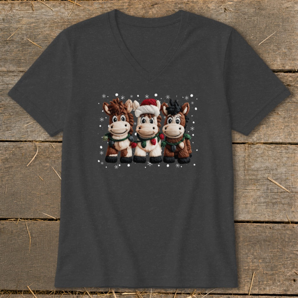 Three cartoon horses in Christmas attire, one wearing a Santa hat, surrounded by snowflakes.