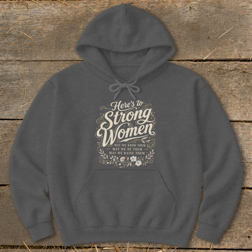 Dark gray hoodie with "Here's to Strong Women" text and floral accents.