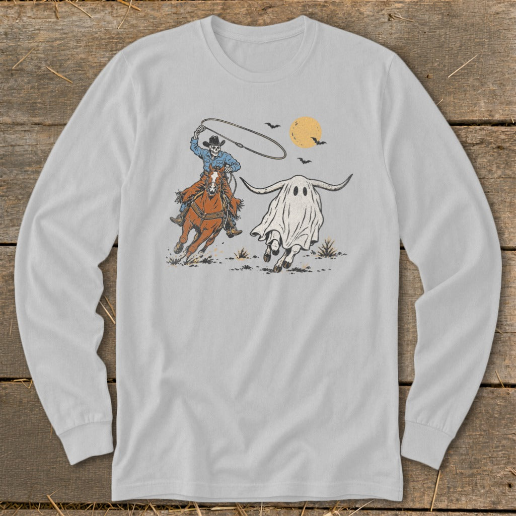 Skeleton cowboy on horse lassos a longhorn ghost under a setting sun.