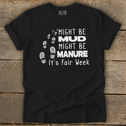Black t-shirt with white text: "Might Be Mud, Might Be Manure. It's Fair Week."