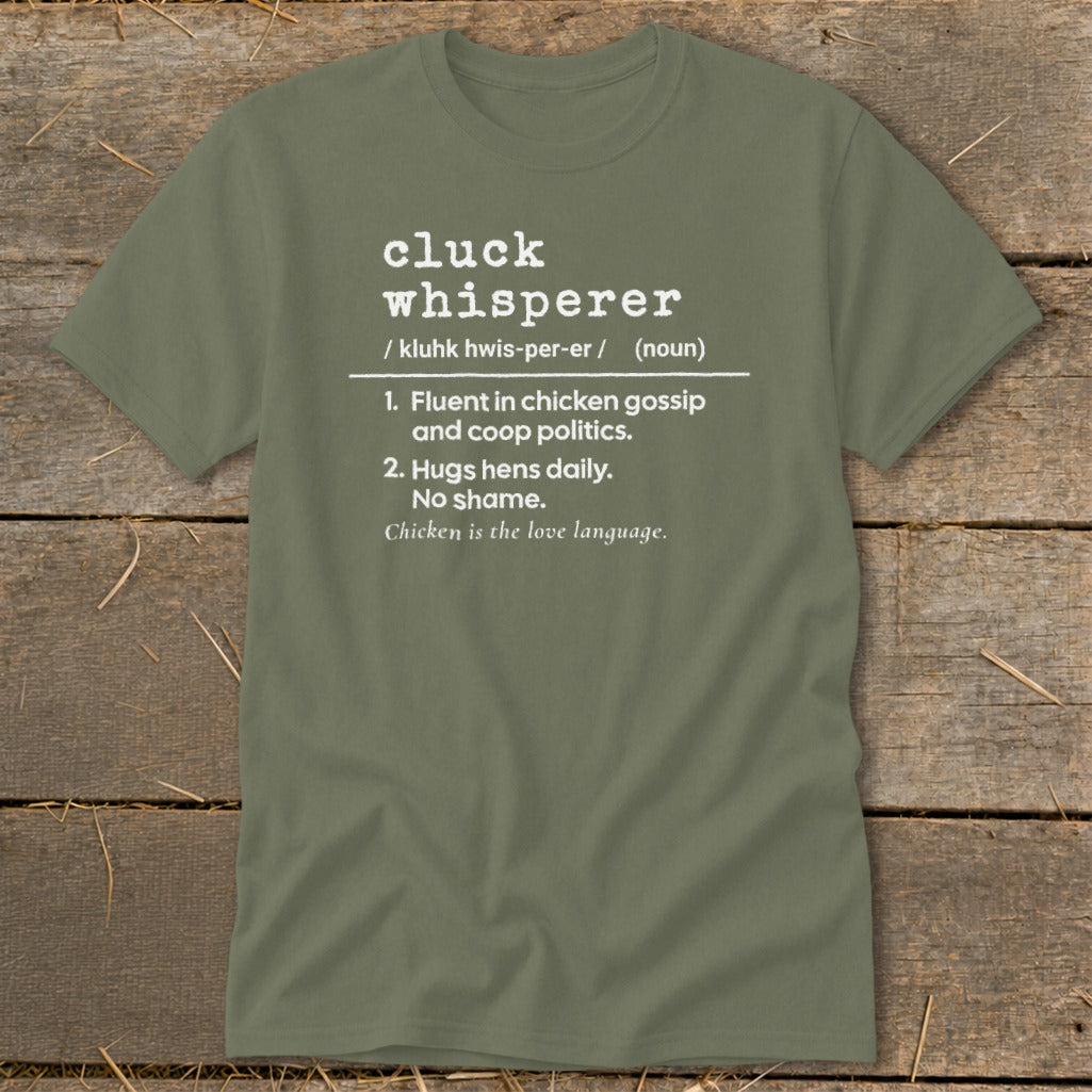 Green t-shirt with "Cluck Whisperer" definition: fluent in chicken gossip and hugs hens.