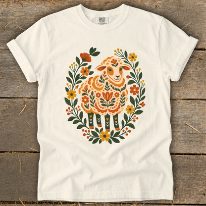 White t-shirt featuring a decorative sheep surrounded by a floral wreath.