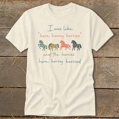 Cream t-shirt with text and four colorful patterned horses.