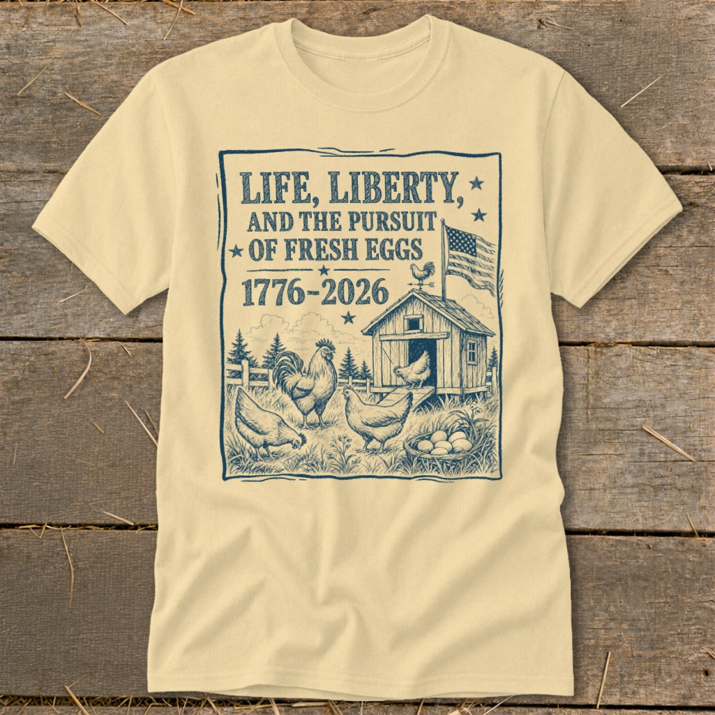 Cream t-shirt with "Life, Liberty, and the Pursuit of Fresh Eggs" text and chicken farm illustration.