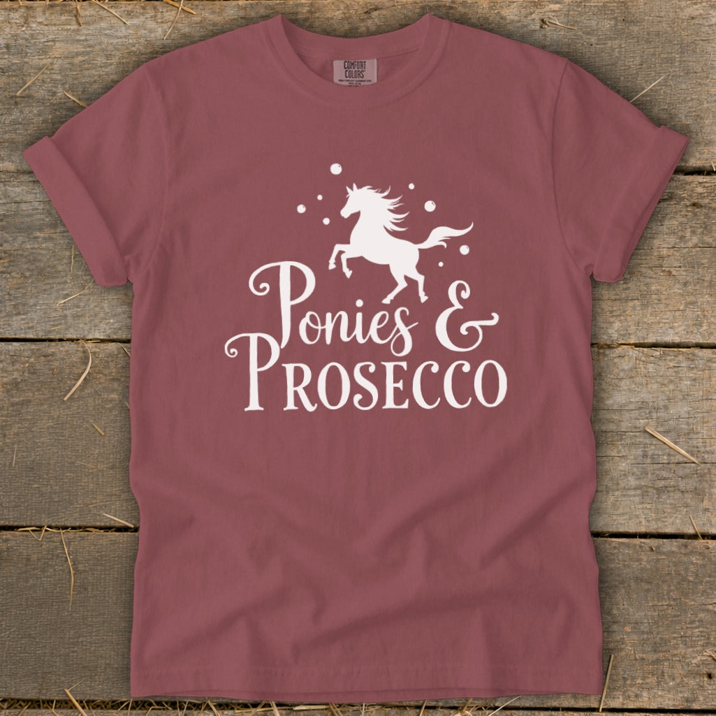 Maroon t-shirt with white graphic of a running horse and "Ponies & Prosecco" text.